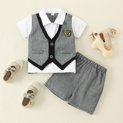 Camisa y shorts de dos piezas simulados con estampado de insignia para niño pequeño