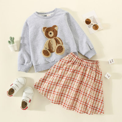 Suéter con estampado de oso para niños pequeños y falda a cuadros