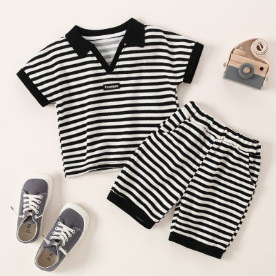 Camiseta y pantalones cortos con bloques de color y cuello de polo a rayas para niño pequeño
