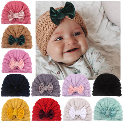 Cappello di lana decorato con fiocco per bebè