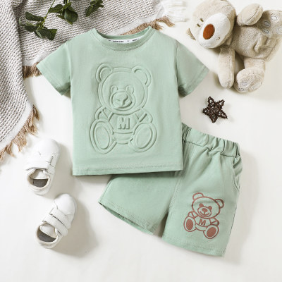 طقم للطفل الصغير مكون من قطعتين، يتضمن قميصًا بأكمام قصيرة بلون صلب ومزين بنمط دب، مع شورت متناسق بنفس النمط.