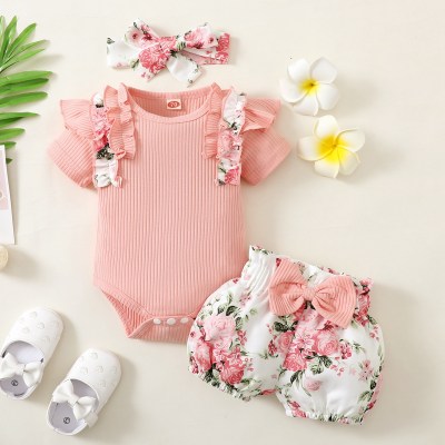 3 pezzi Pagliaccetto a maniche corte con patchwork a costine arricciato per neonata e decorazioni floreali con fiocco e pantaloncini e copricapo