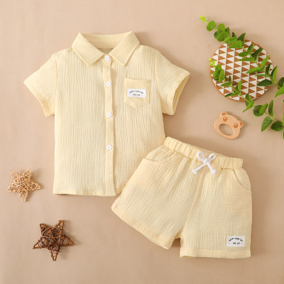 Camiseta y pantalones cortos de tela arrugada sólida con letras para niños pequeños