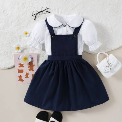 Conjunto informal de dos piezas de camisa con botones delanteros y falda con tirantes y cuello de muñeca con mangas de burbujas para niña pequeña