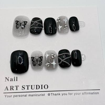 Arte de uñas hecho a mano, arte de uñas corto con cadena de mariposa negra, lindo con un estilo dulce y fresco