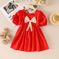 فستان للطفلة الصغيرة مزيّن بنقوش زهور وعقدة على العنق بشكل مربع وأكمام قصيرة.  أحمر